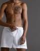 White swimming trunks with script embroidery
